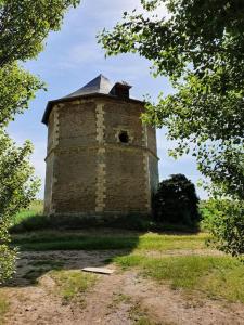 een oude bakstenen toren midden in een veld bij Gite rural cocooning en Baie de Somme in Vron