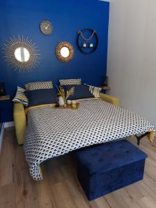 ein Schlafzimmer mit einem Bett und einer blauen Wand in der Unterkunft Gite rural cocooning en Baie de Somme in Vron