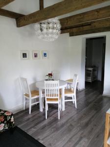 a white dining room table with chairs and a chandelier at Secret garden house in the center of Sigulda in Sigulda