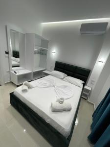ein Schlafzimmer mit einem Bett mit zwei Handtüchern darauf in der Unterkunft Zogaj Guesthouse in Ksamil