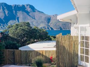 a house with a fence and mountains in the background at BEAUTIFUL VIEW Garden Apartment in Cape Town