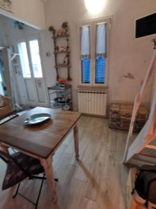 een kamer met een houten tafel en een aantal ramen bij la baracca dei pescatori in Follonica