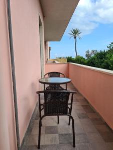 a table and chairs on a balcony with a palm tree at Esposito Guest House in Procida