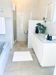 a white bathroom with a sink and a shower at BEAUTIFUL VIEW Garden Apartment in Cape Town