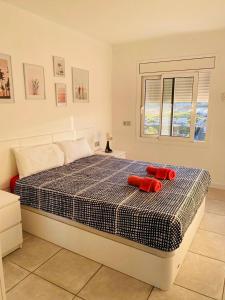 a bedroom with a bed with two red pillows on it at Apartamento frente al mar con piscina in Malgrat de Mar