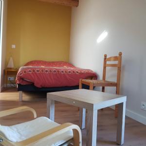Habitación con cama, mesa y sillas. en Appartement entre lac et montagnes, en Saint-Paul-en-Chablais