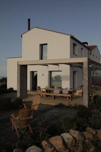 een wit huis met twee stoelen en een tafel bij El Faro Unkempt - Tazones in Villar