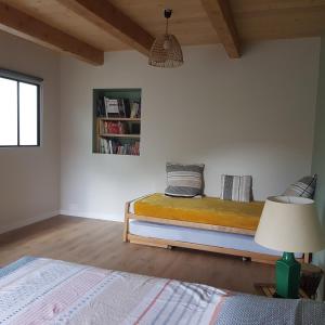 1 dormitorio con 1 cama con lámpara y estante para libros en Appartement entre lac et montagnes, en Saint-Paul-en-Chablais