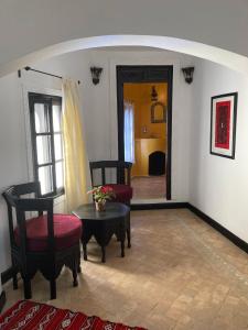 a living room with two chairs and a table and a door at Dar Hannan in Chefchaouene