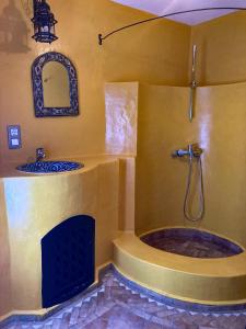 uma casa de banho com um chuveiro e uma banheira com uma lareira em Dar Hannan em Chefchaouene