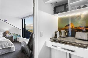 クイーンズタウンにあるAwesome Studio - Amazing Mountain & Lake Viewsのベッドルーム1室(ベッド1台付)、キッチンが備わります。