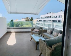 balkon z krzesłami i kanapami w budynku w obiekcie Sea view luxury new apartment Marbella Port w Marbelli
