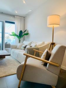 a living room with a couch and a lamp at Sea view luxury new apartment Marbella Port in Marbella