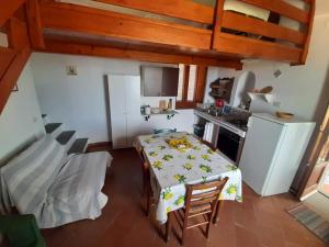 una cucina con tavolo e una piccola cucina con piano cottura di Casa Raia - Overlooking the sea a Procida