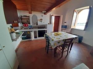 cocina con mesa, mesa y sillas en Casa Raia - Overlooking the sea en Procida
