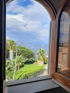 d'une fenêtre avec vue sur l'océan et les palmiers. dans l'établissement Casa Raia - Overlooking the sea, à Procida