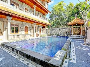 a swimming pool in front of a building at OYO Collection O 91125 Puri Dewa Bharata in Jimbaran