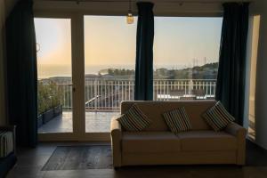 - un salon avec un canapé et une vue sur l'océan dans l'établissement Relais Villa Bonifacio, à Diamante
