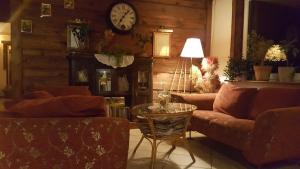 salon z kanapą, stołem i zegarem w obiekcie Centrum Wypoczynku ODYS w mieście Tresna
