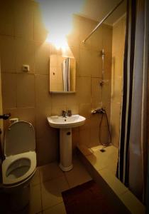 a bathroom with a toilet and a sink and a shower at Economy rooms next to Primosrky Park in Gagra