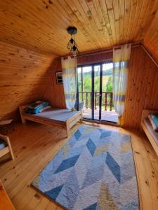 an attic room with a bed and a large window at Domek Anna Zawóz in Zawóz