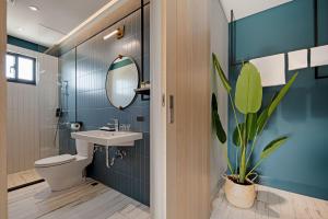 a bathroom with a sink and a toilet and a mirror at 森行旅 Mori Hotel - 近安平老街 in Anping