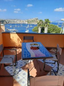 un tavolo e sedie su un balcone con vista sull'oceano di Casa Raia - Overlooking the sea a Procida