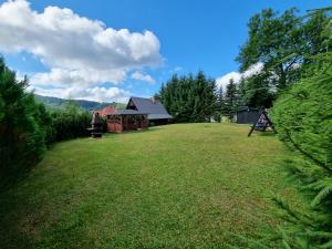 a large yard with a house in the background at Domek Anna Zawóz in Zawóz