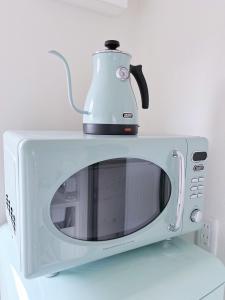 a microwave with a tea kettle on top of it at Necoana Glamping in Fujikawaguchiko