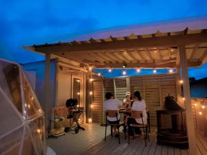 a group of people sitting at a table on a deck at Necoana Glamping in Fujikawaguchiko