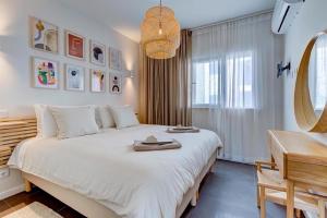 una camera da letto con un grande letto bianco e uno specchio di Luxury Two Bedroom Apartment with Private Roof Terrace and Hot Tub ad Alvor