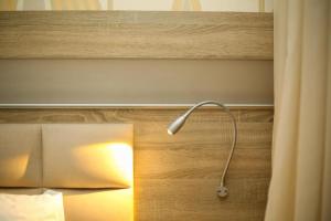 une lampe assise à côté d'un lit dans une pièce dans l'établissement Hotel Partner, à Vlorë