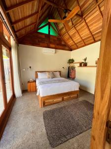 a bedroom with a bed and a wooden ceiling at Jati Kuta Lombok in Kuta Lombok
