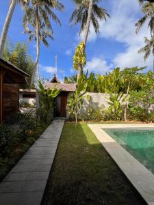 a path leading to a villa with a swimming pool at Jati Kuta Lombok in Kuta Lombok