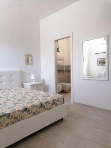 リーパリにあるVilla Porto delle Gentiの白いベッドルーム(ベッド1台、鏡付)