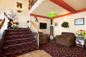 sala de estar con 2 sillas y escalera en Super 8 by Wyndham Las Vegas, en Las Vegas
