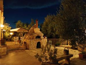 a stone fireplace in a yard at night at Dedo B&B in Terlizzi
