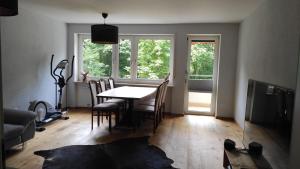 ein Esszimmer mit einem Tisch, Stühlen und Fenstern in der Unterkunft Brilliant Home Messe in Nürnberg