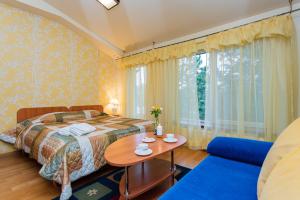 a bedroom with a bed and a table and a couch at Po Jūros Banga in Palanga