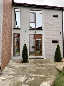 a house with glass doors and two trees in front of it at Cottages Ureki in Ureki