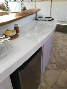 a kitchen with a white counter top with a dishwasher at FARE TEMANEA in Papetoai