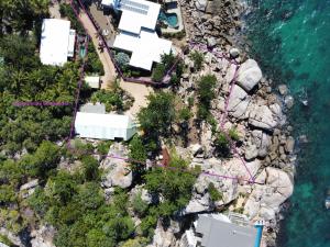 una vista aérea de una casa en las rocas cerca del agua en The Boulders - Oceanfront Couple's Retreat with private pool near ferry en Nelly Bay
