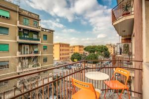 balkon z pomarańczowymi krzesłami i stołem oraz budynkami w obiekcie City Guest House w Rzymie