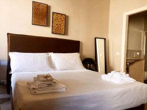 una camera da letto con un letto e asciugamani di Gatto Bianco Santa Caterina a Bergamo