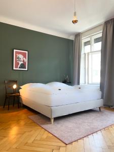 ein Schlafzimmer mit einem großen weißen Bett in einem Zimmer in der Unterkunft Stadtjuwel mit Pfänderblick in Bregenz