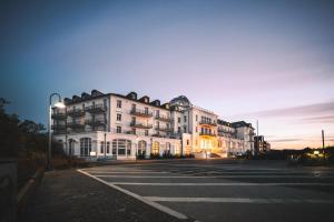 a large white building on a street at night at Strandhotel Kurhaus Juist in Juist