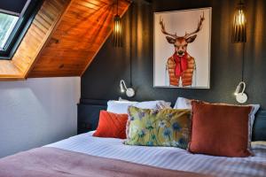 a bedroom with a bed with a deer on the wall at ISKÖ BaseCamp & Hôtel, Col d'Aubisque in Gourette