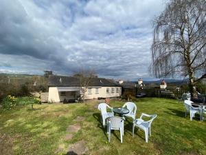 a group of white chairs and a table in a yard at The Griffin Llyswen in Brecon