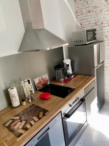 a kitchen with a wooden counter top with a stove at Logement avec jardin privé confortablement équipé in Bagard