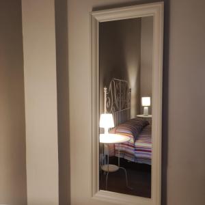 - un miroir en face d'une chambre avec un lit dans l'établissement Appartamento La Rampa, à Bénévent